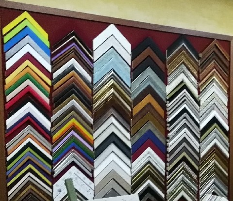 Columnas de molduras de colores vivos sobre panel granate.
