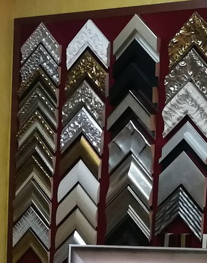Molduras labradas en plata y pan de oro sobre panel granate.